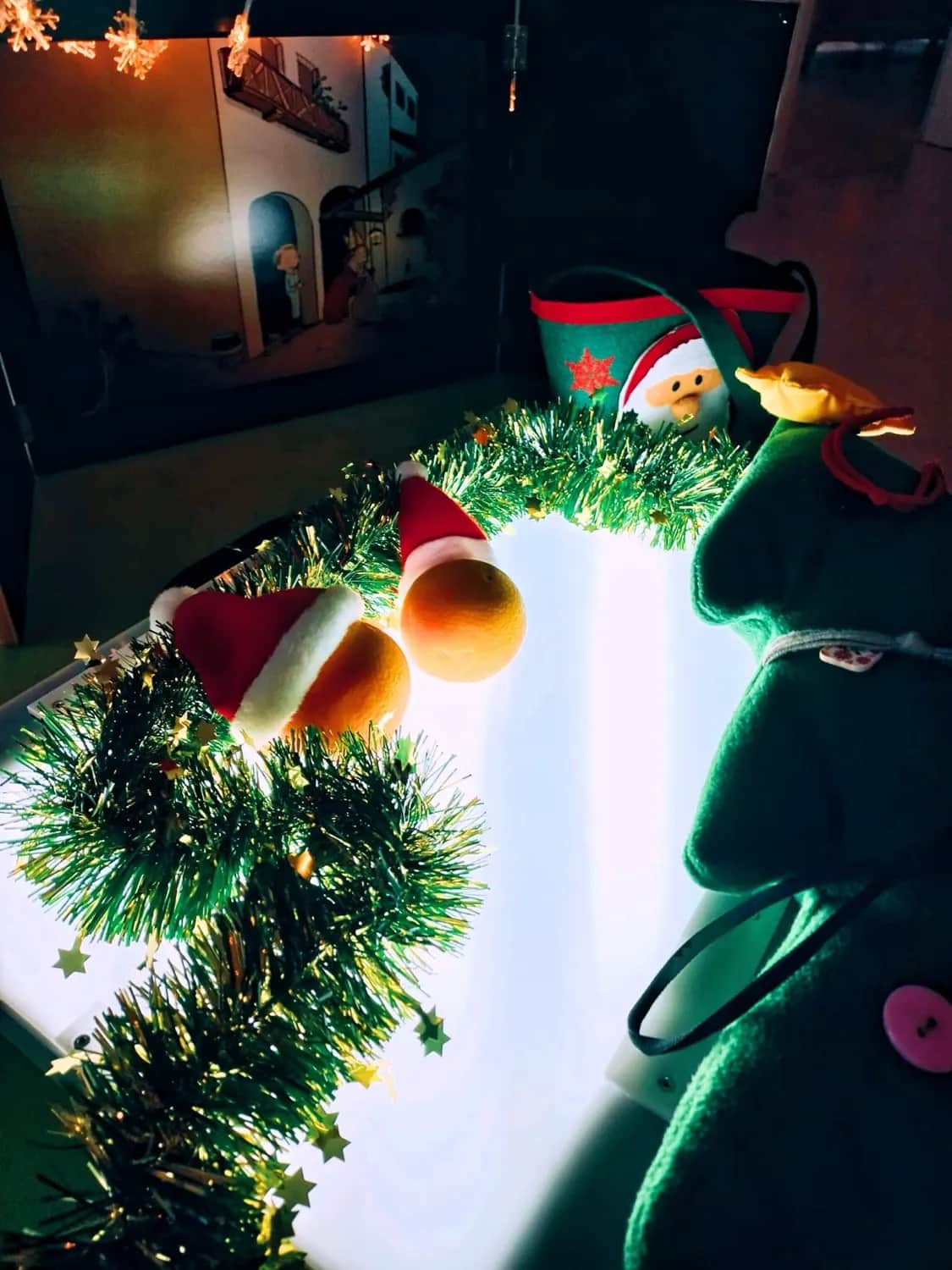 Eine leuchtende Lichterkette mit Nikolausmützen und Tannengirlande