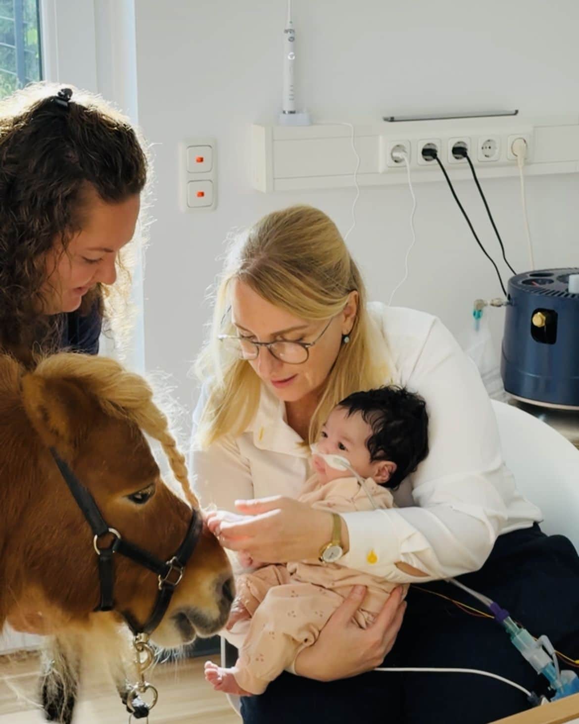 Therapiepony Zappy besucht die kleine Malika, die noch Highflow-Unterstützung bekommt